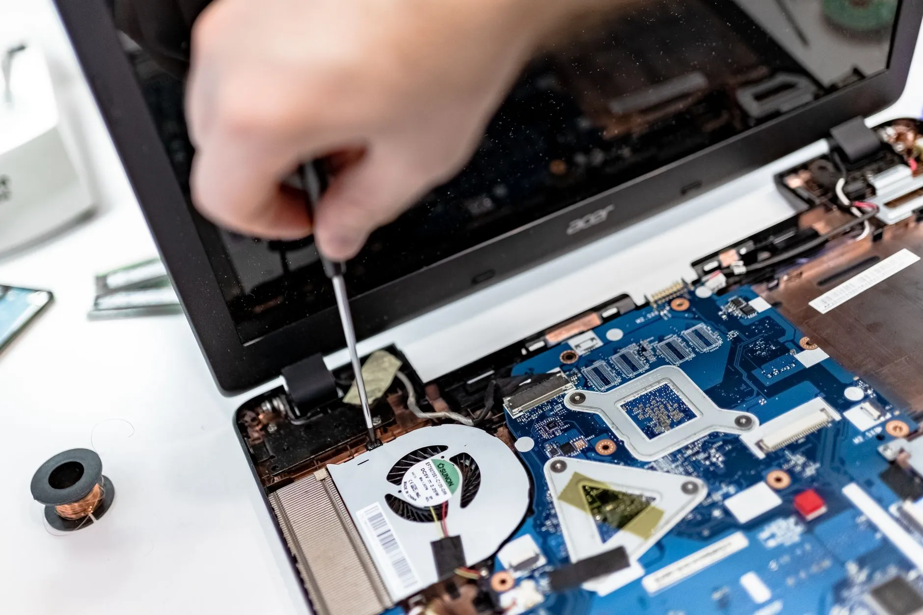 Notebook aberto na bancada técnica da TheComp
